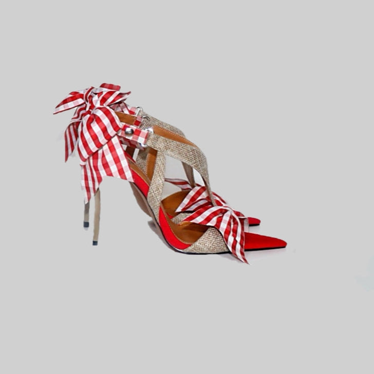 High-heeled shoe with red and white striped design on a gray background